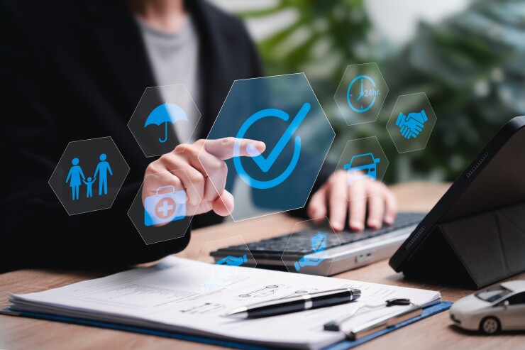 A person using a computer with several holographic images overlayed including a check mark.