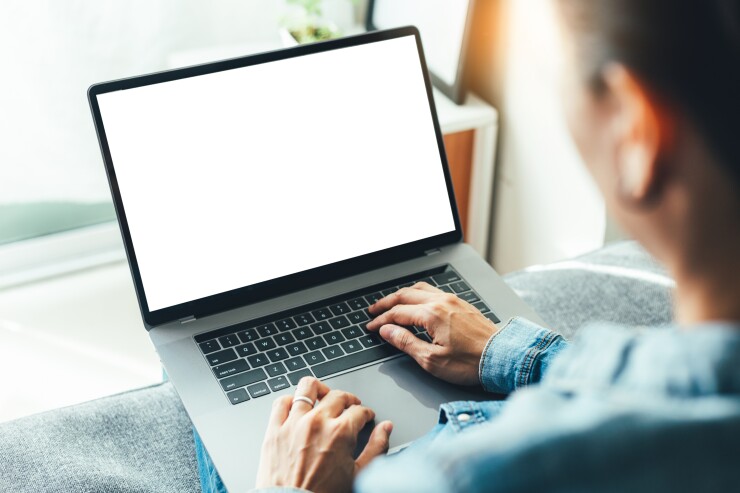 A person using a laptop with a blank screen