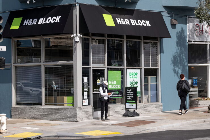 A person wearing a protective mask stands in front of an H&R Block office in San Francisco, California, U.S., on Monday, March 8, 2021. H&R Block Inc. is expected to release earnings figures on March 9. Photographer: David Paul Morris/Bloomberg
