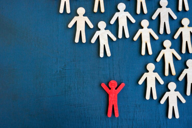 Unique figurine stand out from the crowd from lines of figures.