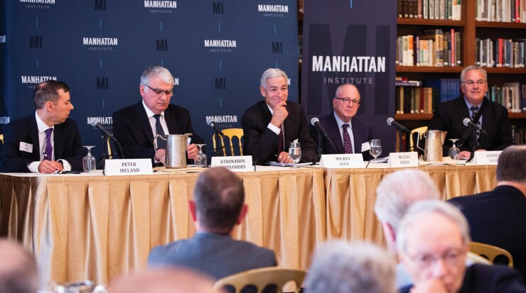 The members of the Shadow Open Market Committee sit at a long table facing an audience.