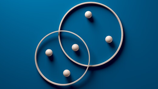 Crossing wooden rings with spheres on blue background.