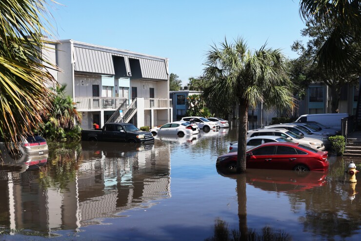 An area with cars and a building that is flooded.
