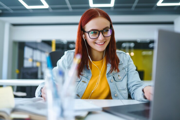 Young employee smiling while looking at the computer