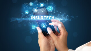 A person using a phone with a holographic insurtech above.