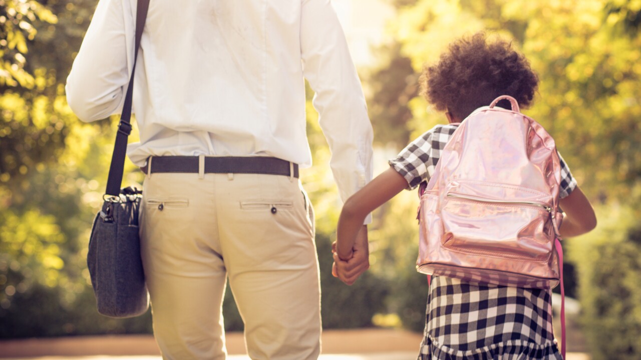Father holding daughter's hand on the way to school; work bag; outside