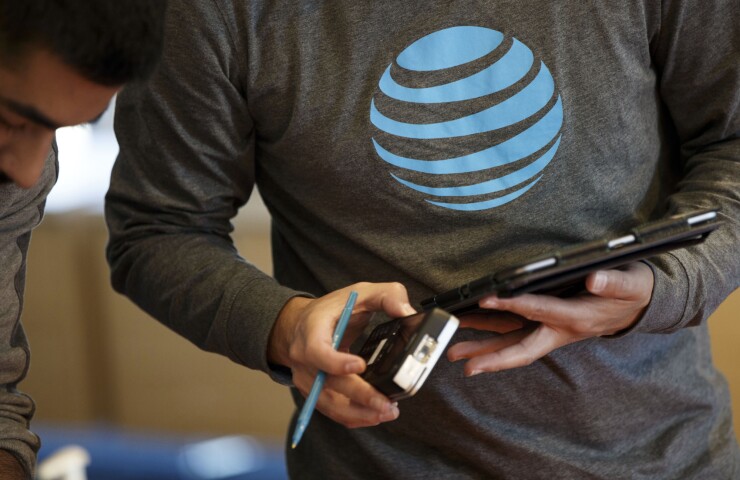 An employee uses a tablet computer at an AT&T Inc. store in Newport Beach, California.