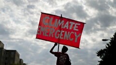 A protester holds a sign that reads "Climate Emergency" while blocking an intersection during the Shut Down DC climate demonstration in Washington Sept. 23, 2019.