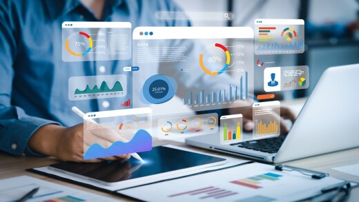 People working on computers with transparent screens floating over the laptops.