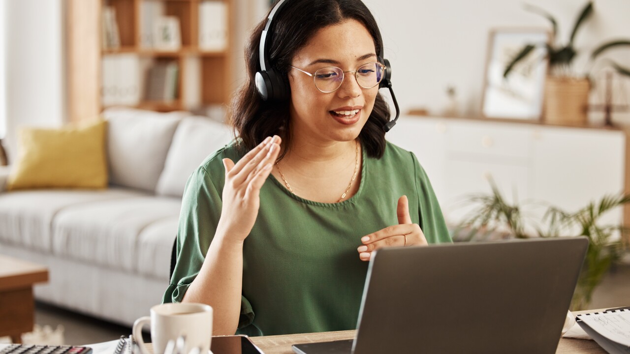 A woman speaking with colleague on video chat.