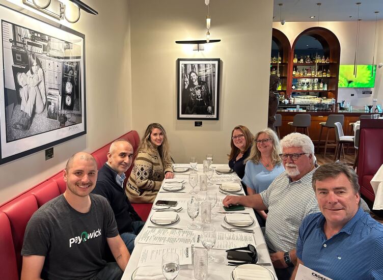 A group of Green Check Verified employees enjoy a dinner together.