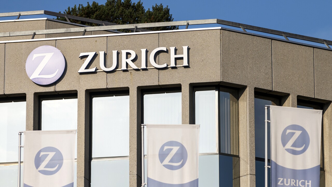 The Zurich Insurance logo on the side of a building with Zurich branded flags.