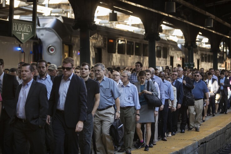 Commuters disembark from New Jersey Transit trains to take ferries or PATH trains during a morning commute to Penn Station on the first day of interruptions in Hoboken, New Jersey.