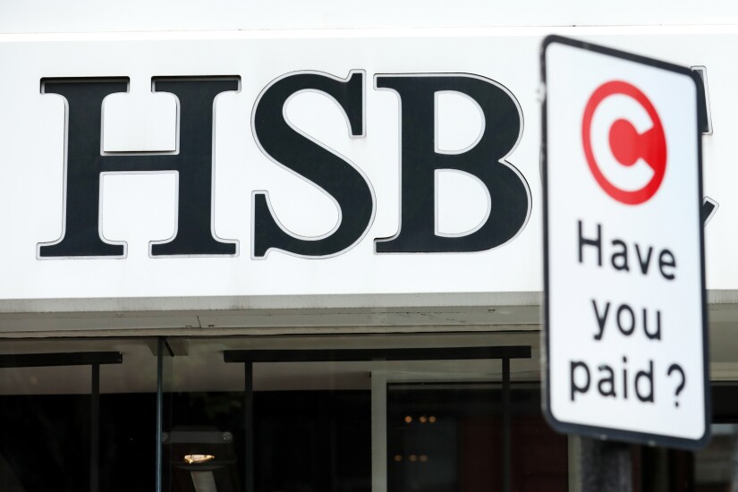 A sign for the London Congestion Charge stands outside a HSBC bank branch in London.