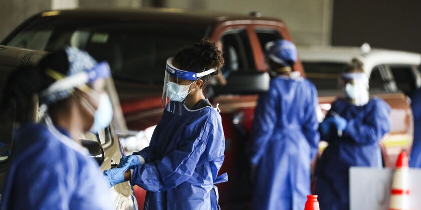 Healthcare workers test people at a COVID-19 testing site in the parking garage for the Mahaffey Theater in St. Petersburg, Florida.
