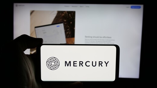 Stuttgart, Germany - 10-31-2024: Person holding cellphone with logo of US fintech company Mercury Technologies Inc. on screen in front of business webpage. Focus on phone display.