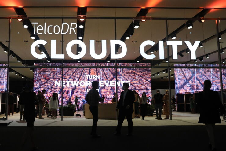 An illuminated 'Cloud City' sign on the TelcoDR Inc. stand on the opening day of the MWC Barcelona at the Fira de Barcelona venue in Barcelona, Spain, on Monday, June 28, 2021. MWC Barcelona, which in 2019 attracted 109,000 attendees from 198 countries, was one of the first major European conference casualties due to the pandemic when it was axed in February last year. Photographer: Angel Garcia/Bloomberg
