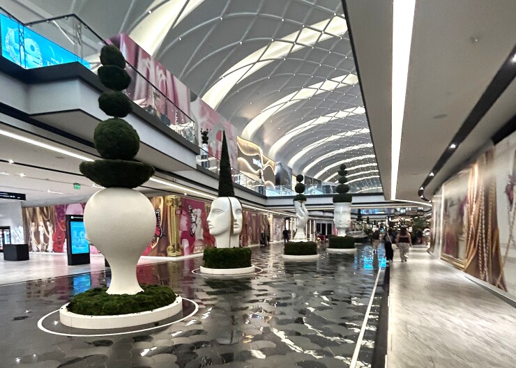 Sculptures in The Avenue, American Dream's high-end wing. The stores on either side of the statues are vacant, so they're covered in posters with colorful graphic art.