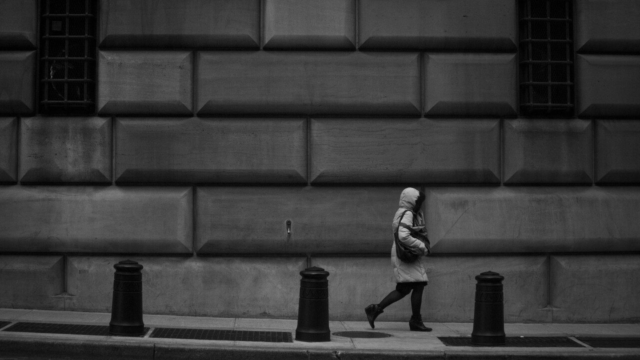 A pedestrian walks past the Federal Reserve Bank of New York building.