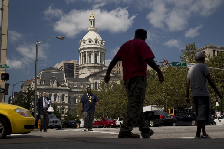 Pedestrians walk past Baltimore City Hall in Baltimore, Maryland, U.S., on Wednesday, Aug. 26, 2015.