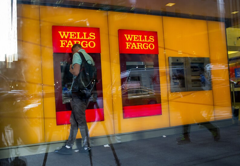A man uses a Wells Fargo ATM inside a branch in New York.