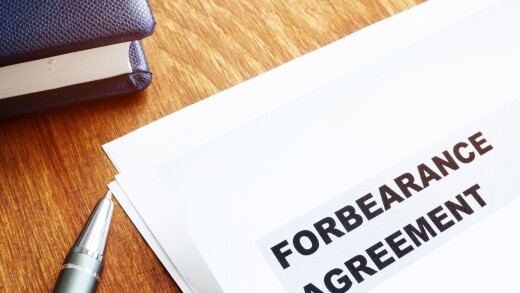 Forbearance agreement papers with pen and notepad.