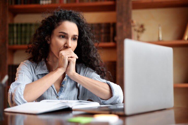 Woman looking concerned at laptop
