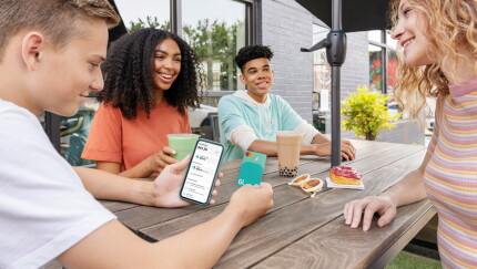 Children looking at the Greenlight app and debit card