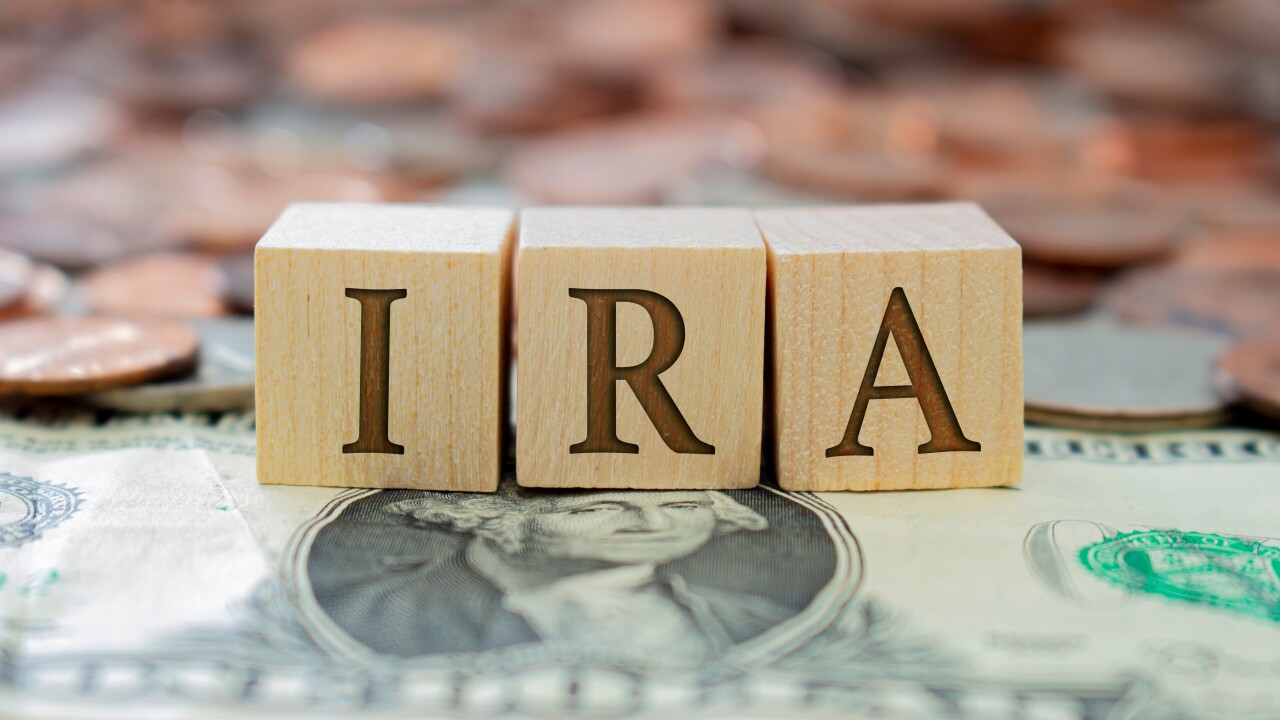 Wooden block with the letter IRA with some money around. Concept: Retirement Plan in USA, Individual Retirement Account