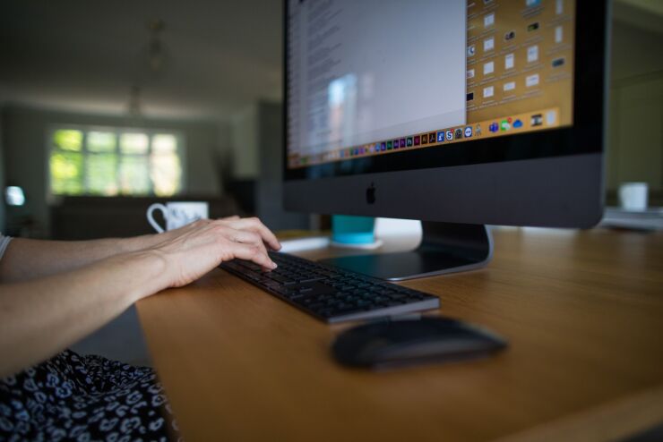 A person's hands using a desktop computer.