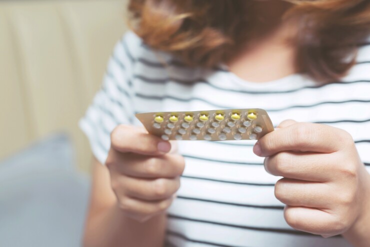 Woman holding birth control pill pack