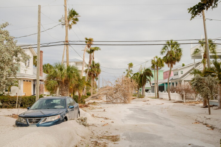 A downed tree and blocked-in vehicle after hurricanes Helene and Milton in St. Pete Beach, Florida in 2024.