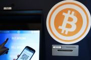 Eugene Aono, a spokesperson for BMEX bitcoin exchange, demonstrates usage of the company's Robocoin-branded automated teller machine (ATM) at The Pink Cow restaurant and bar in Tokyo.
