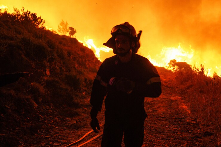 A firefighter near a wildfire in Dionysos.