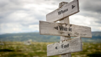 when will it end text on wooden signpost outdoors in nature..to