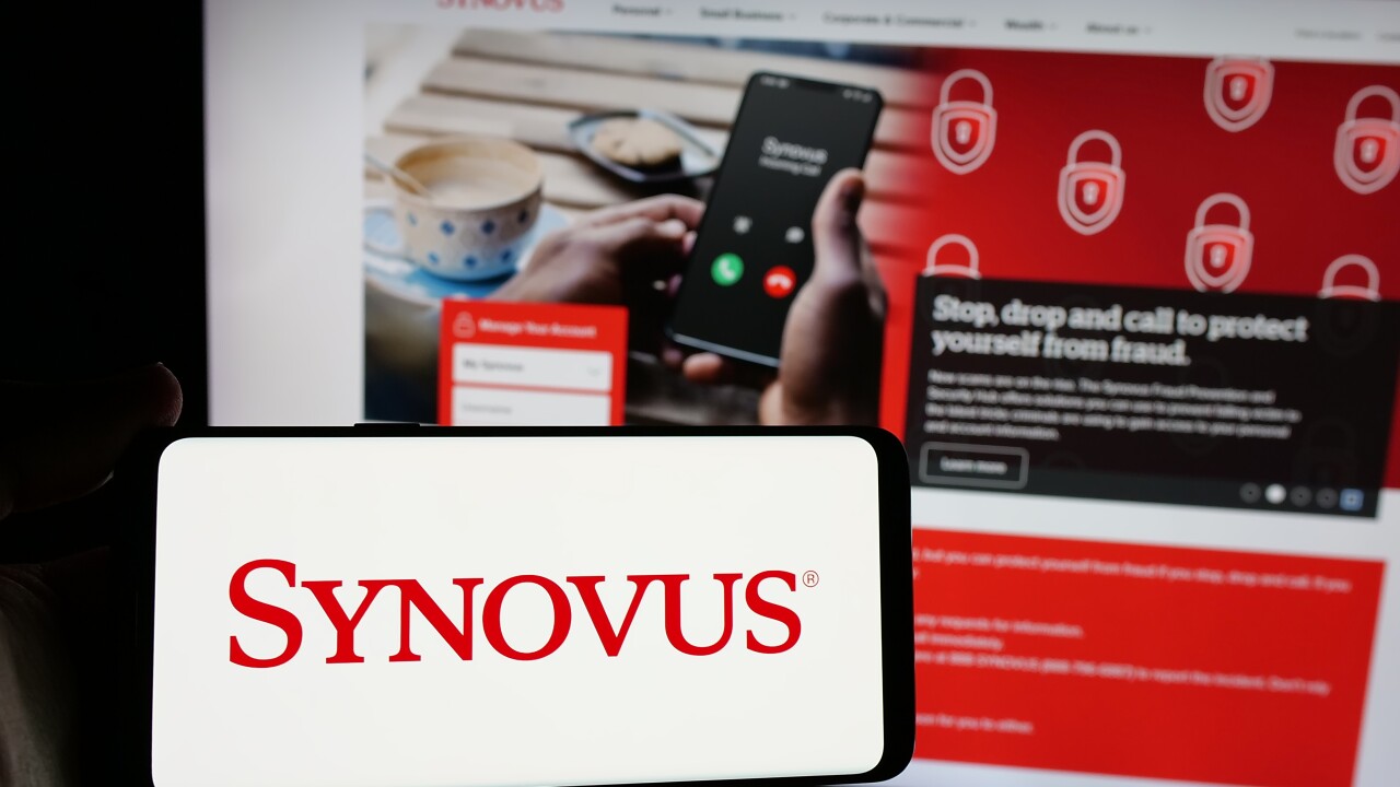 Stuttgart, Germany - 01-09-2025: Person holding smartphone with logo of US banking company Synovus Financial Corp. on screen in front of website. Focus on phone display.