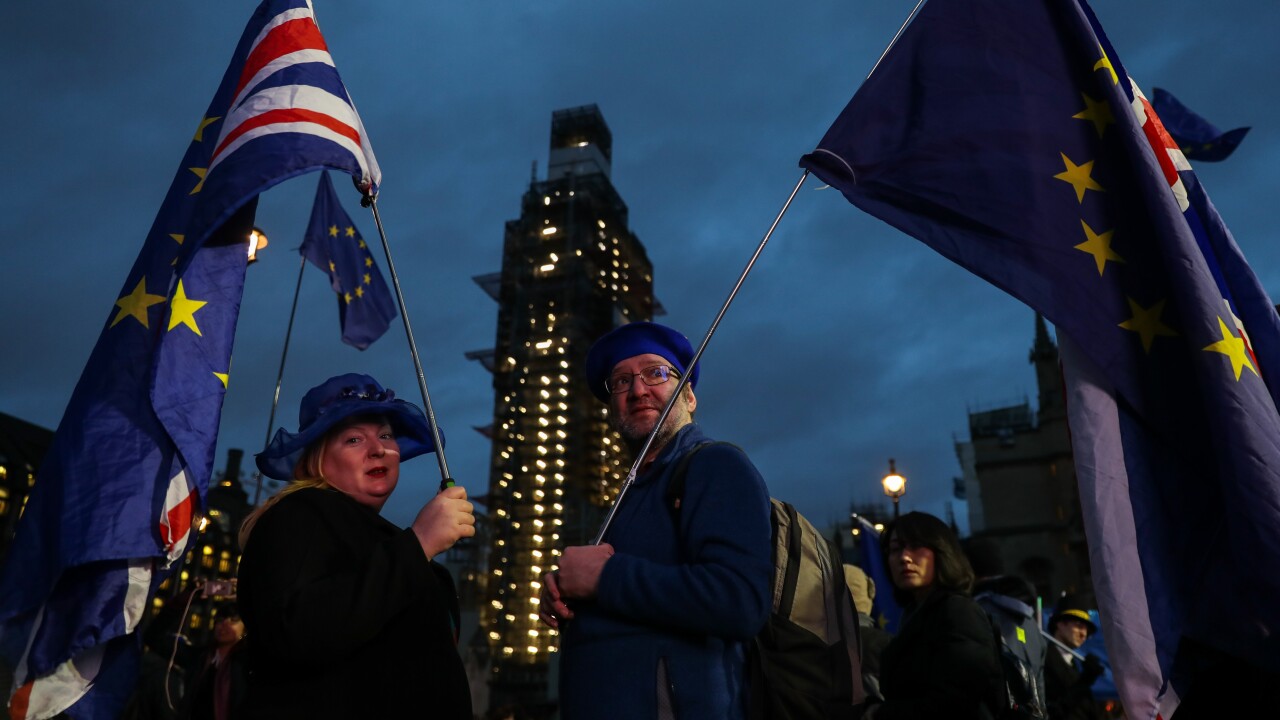 Anti-Brexit demonstrators hold European Union and British Union flags outside of the Houses of Parliament in London on Jan. 15, 2019.