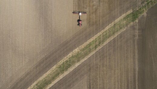 A tractor pulls a planter through a field as corn is planted in Illinois.