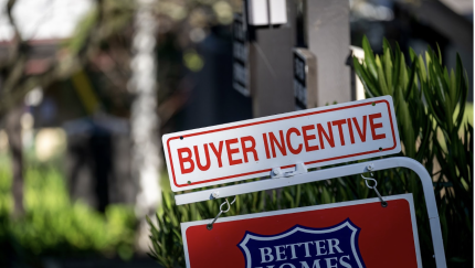 A picture of a for-sale sign outside a house with another sign that says "buyer incentive" on top of it.