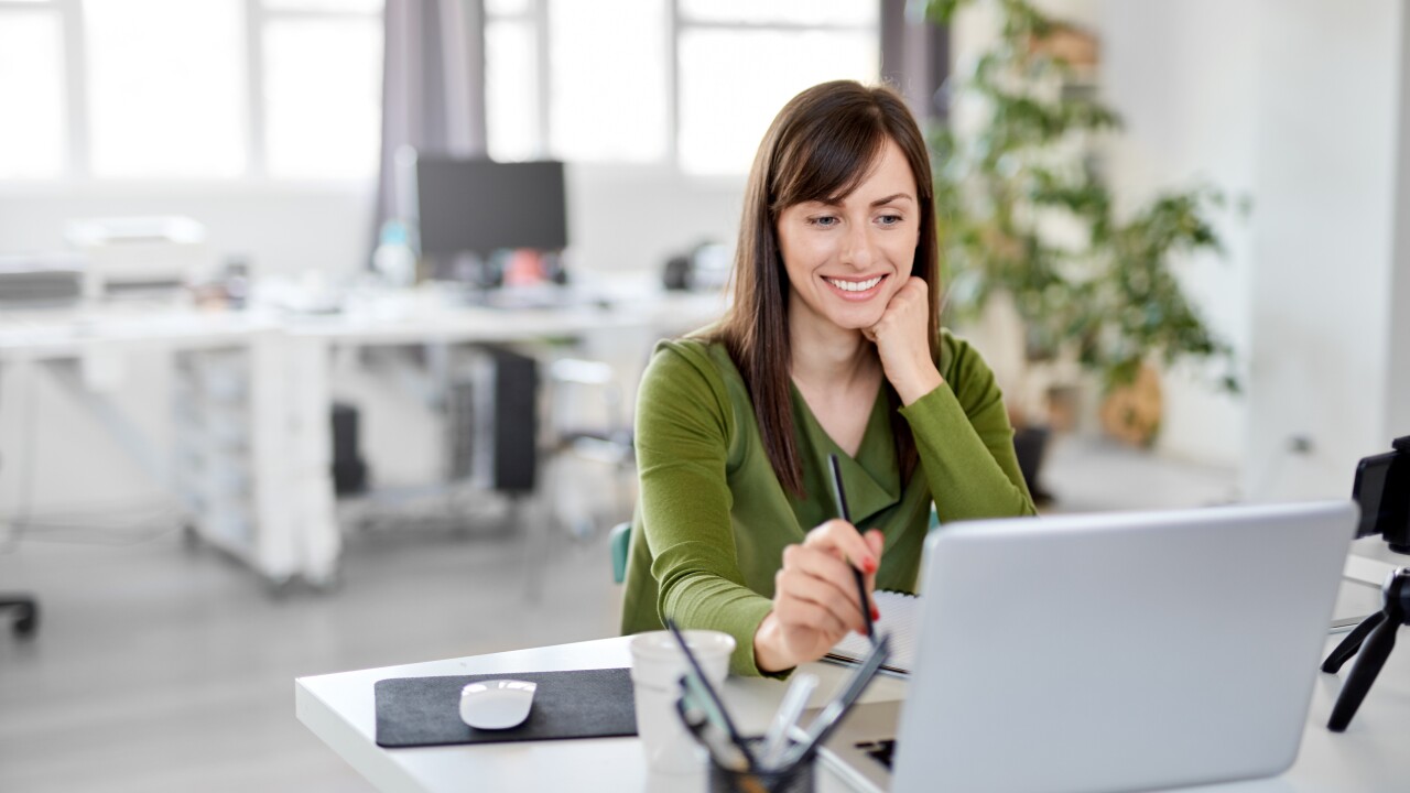 Woman looking at laptop working at desk