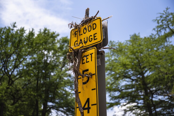 Debris on top of a 5-foot yellow flood gauge