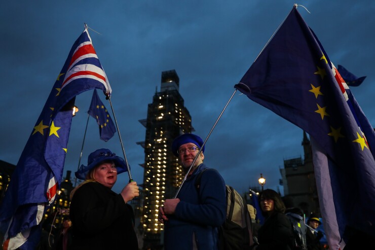 Anti-Brexit demonstrators hold European Union and British Union flags outside of the Houses of Parliament in London on Jan. 15, 2019.