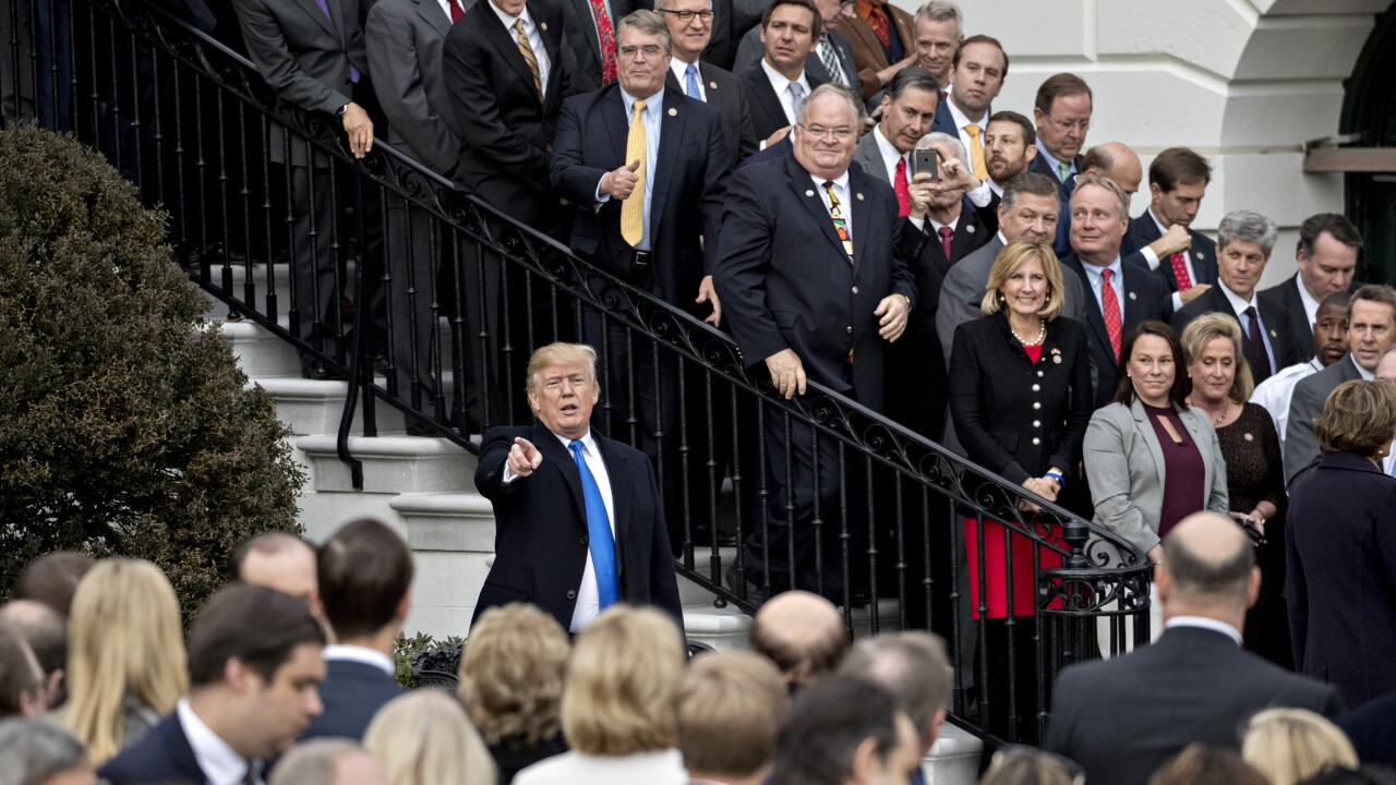 President Donald Trump, center, gestures toward attendees after speaking during a tax bill passage event with Republican congressional members of the House and Senate on the South Lawn of the White House.