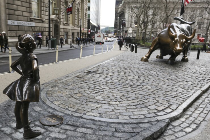 Bronze statue of little girl stares down bull on Wall Street Bloomberg News