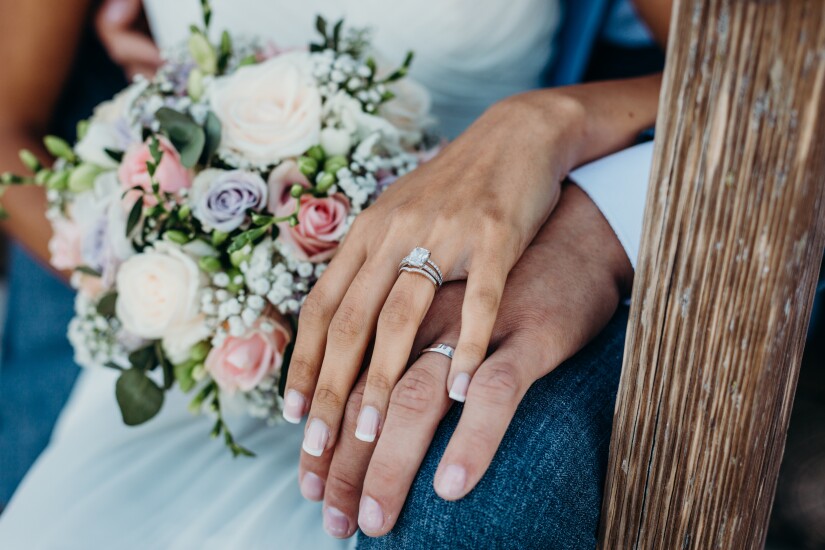 Newlywed couple hands with engagement and wedding rings