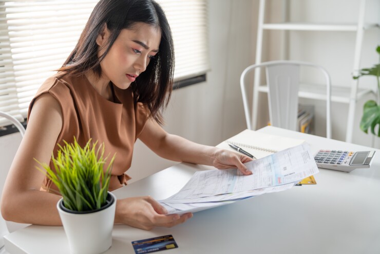 Young woman looking at paperwork at table