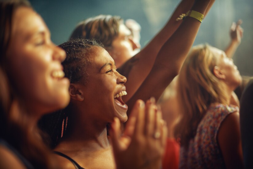 Having the time of their lives. Young girls in an audience enjoying their favourite bands performance.