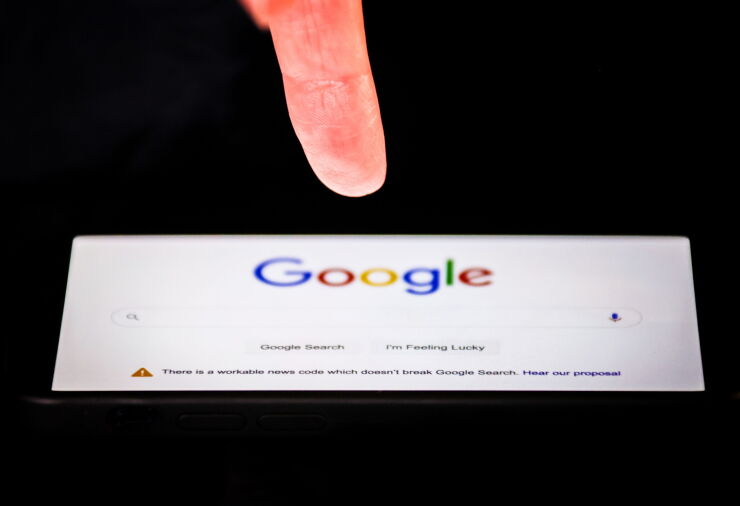 A link to Google's proposal to a workable news code on the company's homepage, arranged on an iPhone in Sydney, Australia, on Friday, Jan. 22, 2021. Google threatened to disable its search engine in Australia if it’s forced to pay local publishers for news, a dramatic escalation of a months-long standoff with the government. Photographer: David Gray/Bloomberg