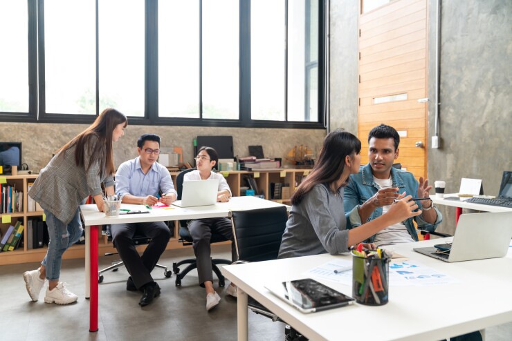 Employees having different conversations in the office.