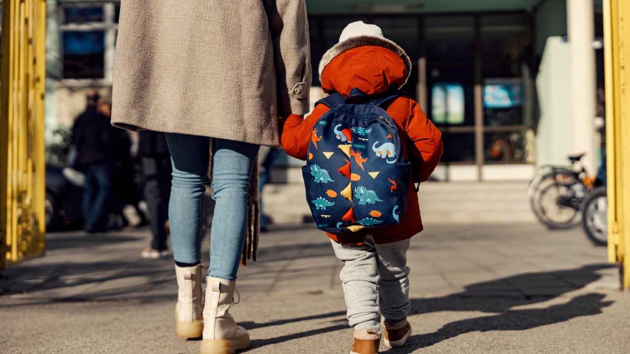 Mother walking child into school, daycare